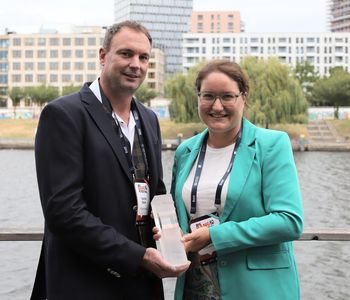 Zwei Personen mit Glas-Pokal am Spreeufer in Berlin